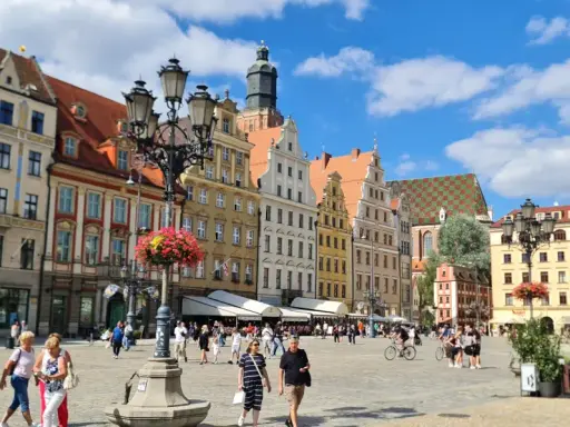 Tętniący życiem Rynek we Wrocławiu, kolorowe kamienice i ludzie spacerujący po placu. To wspaniałe wrocławskie atrakcje!