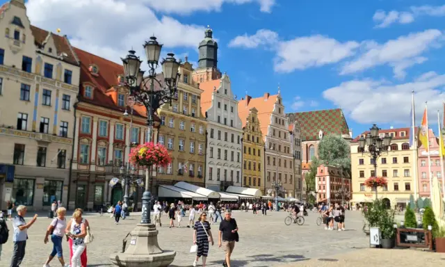 Tętniący życiem Rynek we Wrocławiu, kolorowe kamienice i ludzie spacerujący po placu. To wspaniałe wrocławskie atrakcje!